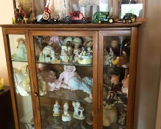 Glass hutch all dolls and precious moments dolls  also for sale. Cast iron John Deere and more 
