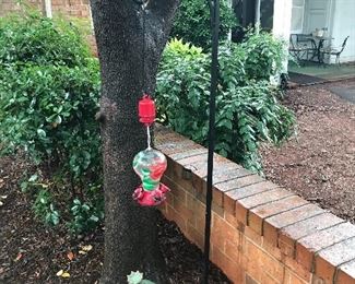 Wrought iron shepherd's hook; hummingbird feeder; ceramic frog