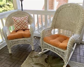 There are several pieces of white wicker furniture