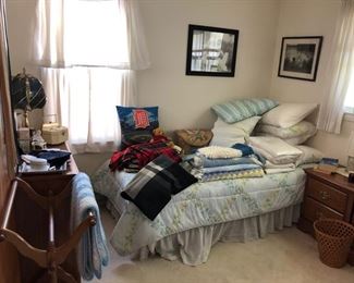 Twin beds, bed linens and quilt rack.