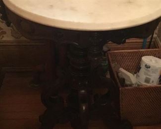 Marble top black maple round table with wheel feet $375