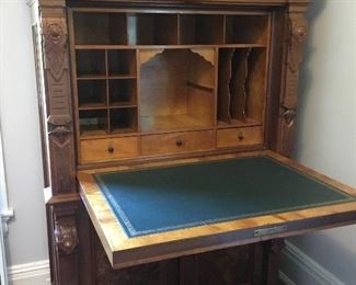 Gorgeous secretary with intricate carving and storage and leather writing surface