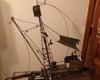 metal sail boat . there is a metal sail that attaches to it.