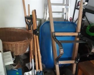 Many gardening tools, shovels, rakes , hoes and wheelbarrow