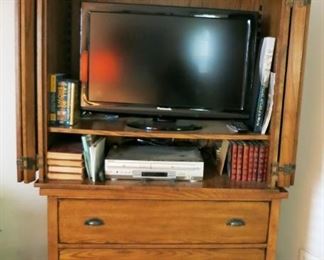 Entertainment stand w/ 3 drawer storage, flatscreen TV, misc. books, CD's, etc.