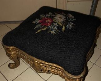 Very old cast iron footstool with needlepoint cushion cover