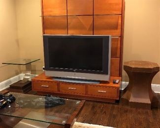 Contemporary entertainment center with display shelves & drawers (72” L x 83.5” H x 27” D) and leather accent table. (24”W x 24” D x 30” H). Plus unique glass/wood/metal accent table. 