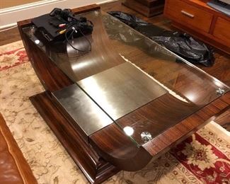 Unique, contemporary coffee table in wood and glass.  51” L x 31” W x 18” H