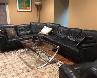 Relax in a this black leather sectional and recliner.  Brushed silver and glass coffee table and large 8 x 10' area rug with grey & black accents.  