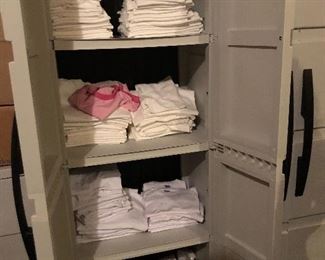 A stock of white t-shirts in a variety of child sizes.  
