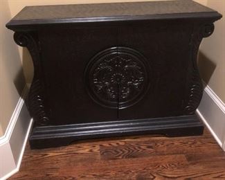 Black accent table with medallion decor. 