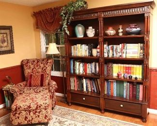 View of bookcase with chair and ottoman.