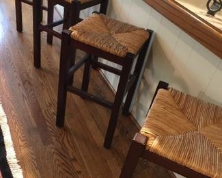 Four woven-top stools.