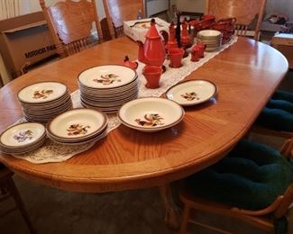 An Oak Table and 6 Chairs with Leafs that has basically never been used. A collection of wonderful Colorful 'Poppy Trail' Rooster Pottery Dishes from California.