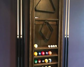 Pool table includes wall rack with cues and balls 