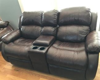 Brown leather reclining / rocking loveseat with storage center