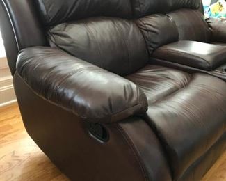 Brown leather reclining / rocking loveseat with storage center