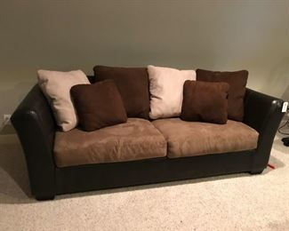 Two-tone sofa with tan / brown pillows and pair of matching chairs