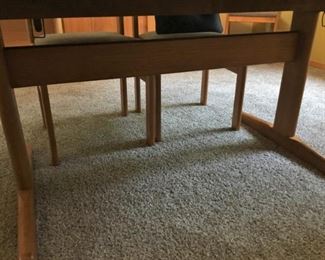 There is a cross beam underneath the table between the two legs. (Sturdy Construction).