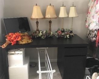 Black wooden desk; lamps; computer monitor