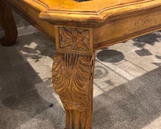 Carved wooden coffee table with glass top