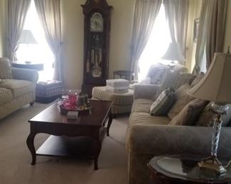 Formal Living room with Grandfather clock , wooden tables, lamps and wall art. Barely sat in this room