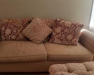 sofa and love seat with many pillows and ottoman