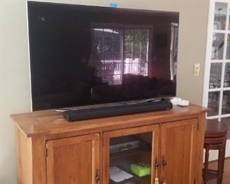 Large flat screen tv and Wooden TV stand that is 63" across 36" high and 22" wide