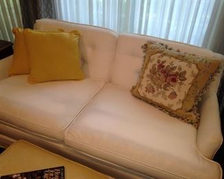 White loveseat; decorative pillows