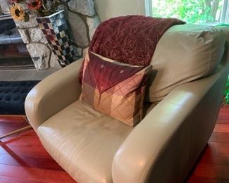 Sandy colored leather chair, blanket and pillow