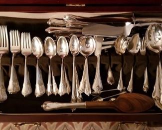 Wallace Grand Colonial sterling flatware set. 113 pieces. 120 Troy ounces. 12 dinner forks, 12 dinner knives, 10 butter knives, 18 salad forks, 24 teaspoons, 10 soup spoons, 8 iced tea spoons, 3 salt spoons, 1 spreading knife, 1 large slotted spoon, 1 small slotted spoon, 1 serving fork, 1 pie server, 1 carving knife, 1 carving fork, salad fork and spoon, 1 (3-tine) cocktail fork, 1 (2-tine) cocktail fork, 2 serving spoons, 1 ladle, 1 scalloped spoon, 1 seashell spoon, 1 spork