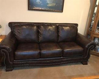Large leather sofa with carved wood feet. This looks like brand new. There are two of these nice sofas. Each sofa is 88 inches wide.