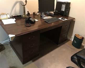 Wood desk with file drawers.