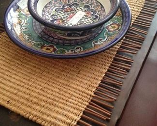 Hand-painted dishes from Mexico; one of several woven placemats