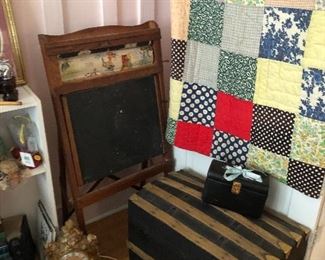 Country quilt on the door. Patchwork beauty. Hump back trunk. Old chalkboard on stand.