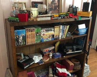 Love this hand made bookshelf. Filled with fun stuff. From matchbook cars to miniature train cars alongside books on every subject as well as old John Wayne movies