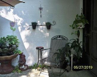 4th pcs to the fountain is Red Girl with Basket right next to fountain, Black and Red Metal Plant stand, 2nd Vintage Black Wrought Iron Rocker Style Chair.