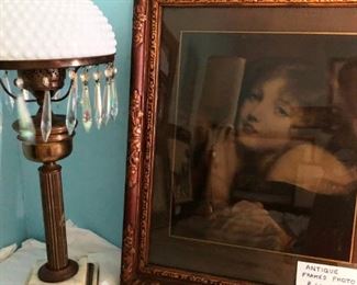 Antique brass lamp with crystals and milk glass shade.  Also very old photograph of unknown young woman