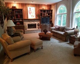 Designer couch, chairs, ottomans, coffee tables, TV, books, lamps, decorator items.
