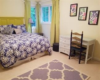 Full size bed, rug, wicker desk, decorator items.