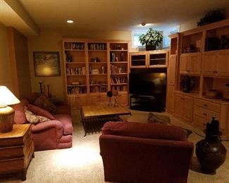 TV, couch, coffee table, lighting, floral arrangements, books, pottery, decorator items.