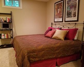 King size bed, wrought iron headboard, comforter set, shelving, artwork