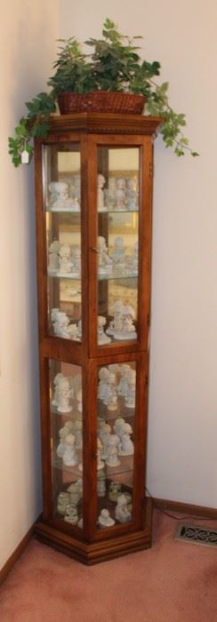 Curio cabinet is filled with Enesco, Precious Moments figurines.  