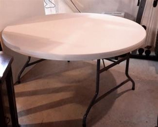 Round table with fold-up legs. 59" round by 29" tall.