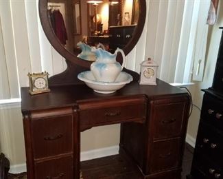 Antique vanity with round mirror, pitcher and bowl, & clocks