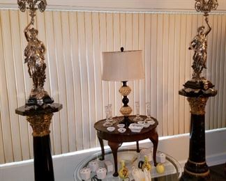 Matched pair of bronze sculptures/candelabras with quadruple sterling silver overlay. Sculptor was Jean Louis Gregoire (1840-1890) from France. They adorn heavy marble bases. In the center, there are 2 accent tables, several vases, crystal candlesticks, & Lenox swans.