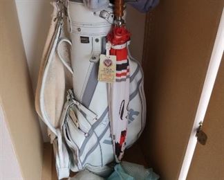 Three sets of golf clubs and lots of golf accessories