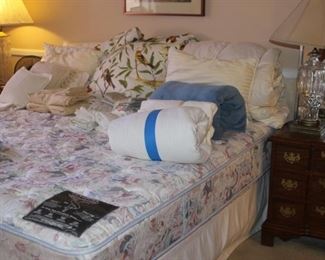 King size bed, linens, comforters, cushions, blankets and pillows.