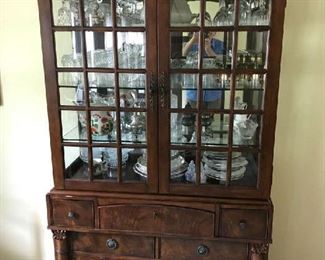 A china cabinet filled with crystal and plates