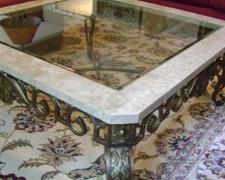 Glass top coffee table with metal scroll trim measures 42 by 42.